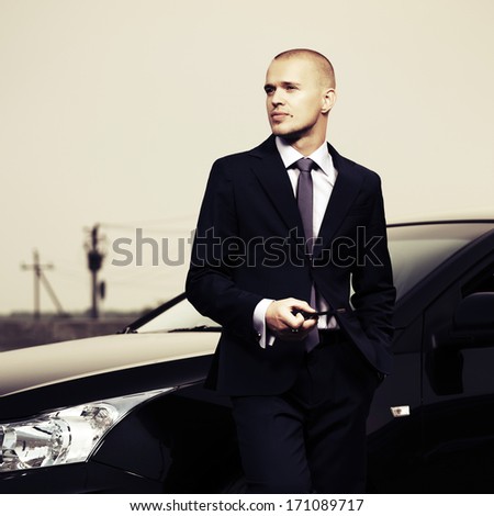 Young Businessman With A Cell Phone At The Car