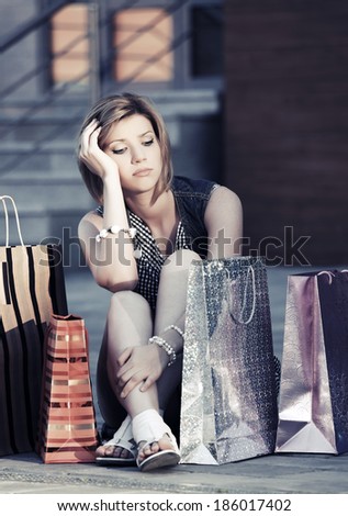 Tired young woman with shopping bags