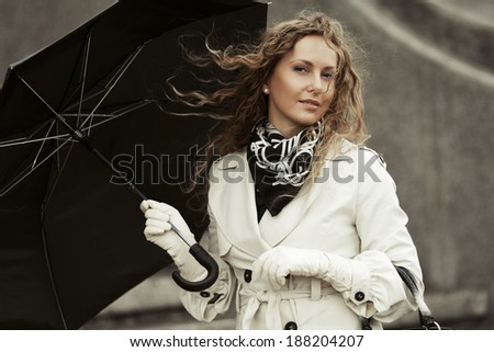 Happy beautiful woman with umbrella in the rain