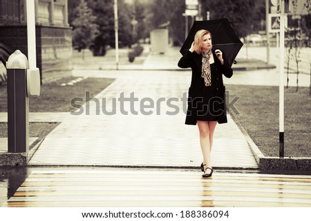 Fashion woman with umbrella in the rain
