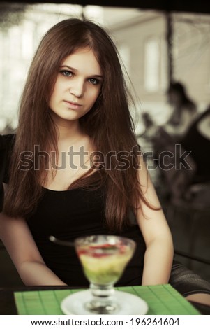 Young woman with ice cream at sidewalk cafe