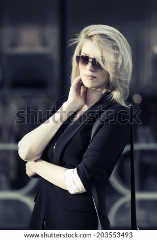 Young fashion business woman walking on the city street