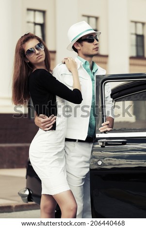 Young fashion man and woman at the retro car