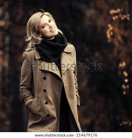 Happy young blond fashion woman in autumn forest