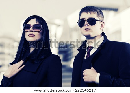 Young fashion business couple against office building