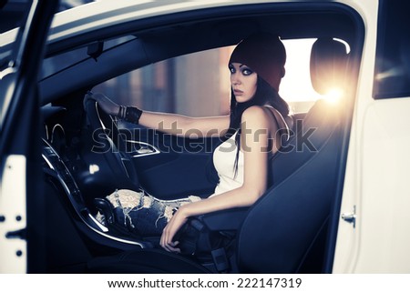 Fashion young woman sitting in a car