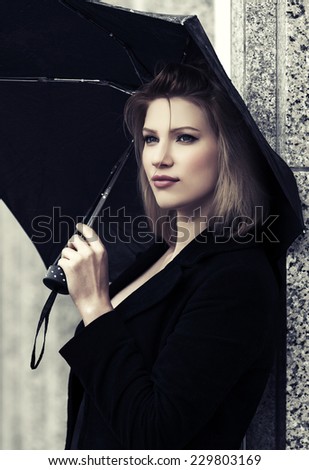 Happy young fashion woman with umbrella in the rain