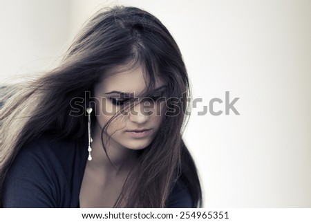 Sad young woman with long hairs looking down