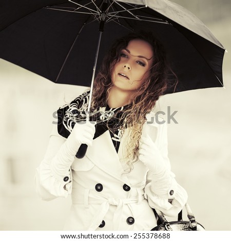 Beautiful fashion woman with umbrella in the rain