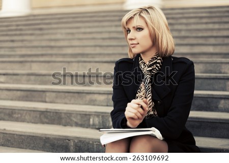 Fashion business woman with notebook sitting on the steps