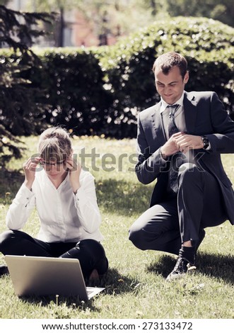Young business people using laptop in a city park