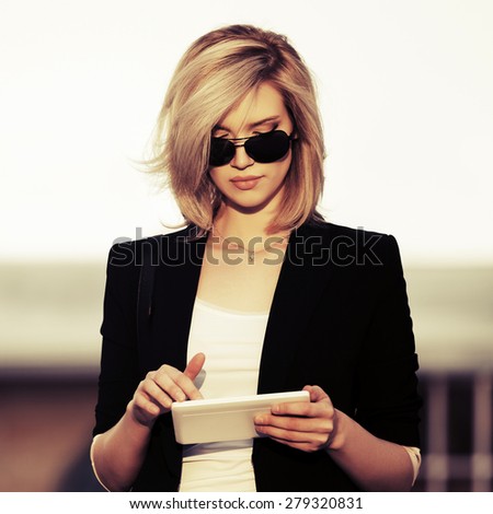 Young fashion business woman using tablet computer outdoor