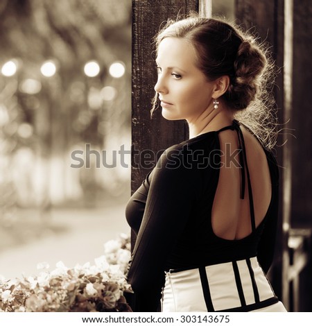 Sad beautiful fashion woman standing on the porch