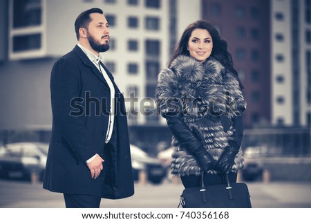 Happy young fashion couple walking in city street. Stylish male and female models outdoor