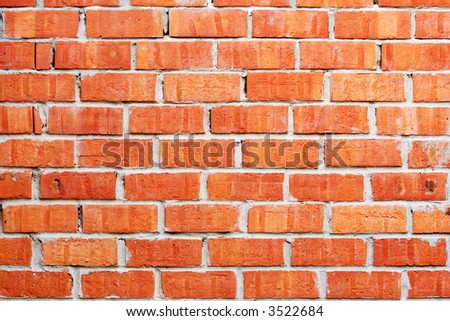 Simple brick wall laid with a red brick.