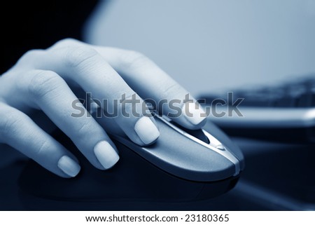 Female hand holding the wireless computer mouse.