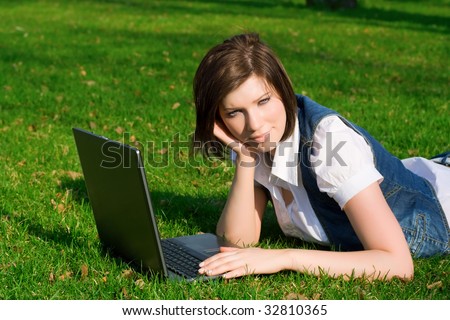Young woman working on laptop on nature.