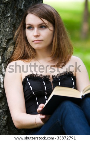 Thoughtful young woman reading on nature.
