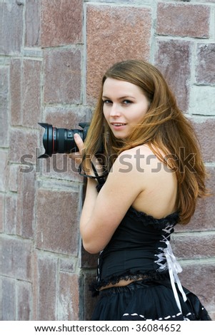 Young woman holding a digital photo camera.