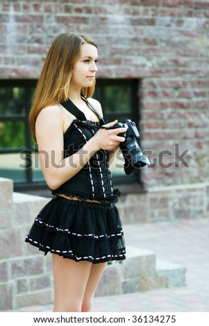 Young woman holding a digital photo camera.