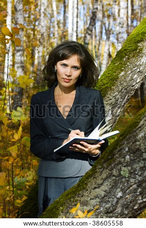 Young businesswoman writing in the notebook on nature.