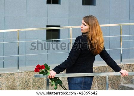 Sad woman holding a red roses.