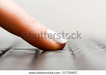 Female finger typing on keyboard.