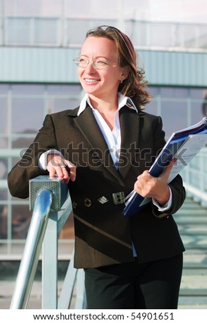 Happy businesswoman on the stairway of airport.