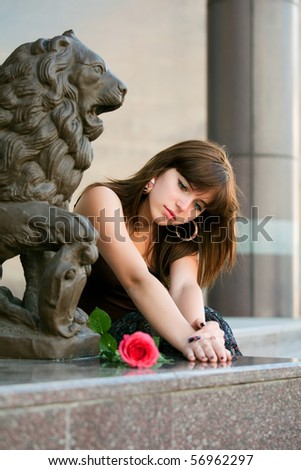 Sad young woman with red rose.