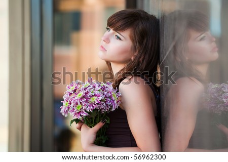 Sad young woman with chrysanthemum.