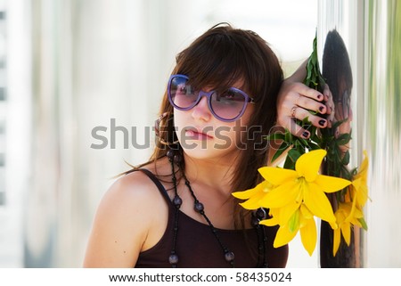 Pensive young woman with yellow lily.