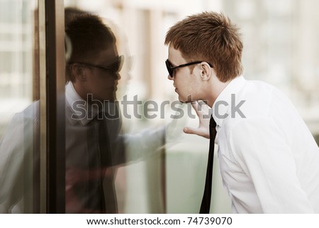 Young man looking through a window