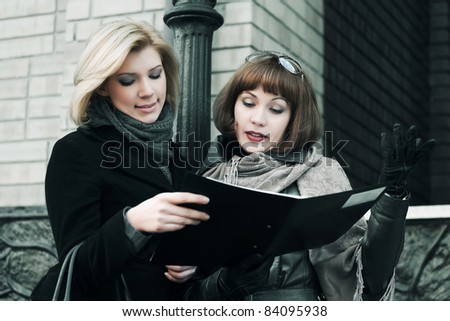 Two young businesswomen with financial reports