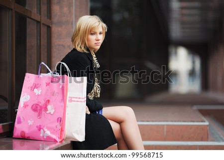 Sad young woman with shopping bags