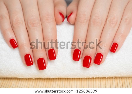Manicure - nice manicured woman nails with red nail polish