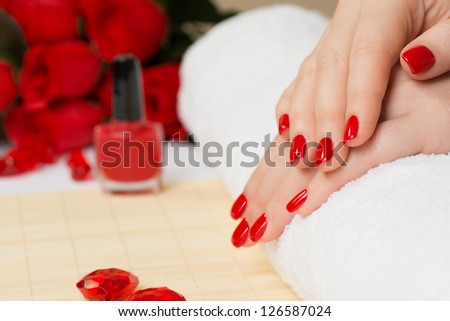 Manicure - Beautiful manicured woman\'s nails with red nail polish on soft white towel.