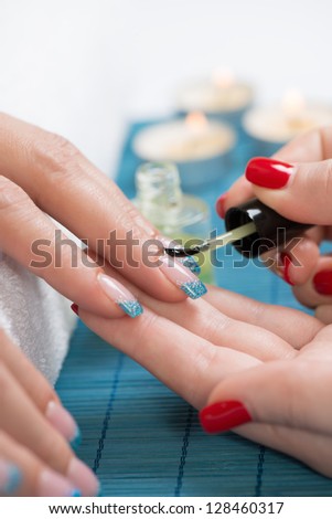 Manicure - Manicure treatment, applying cuticle oil on woman nails with very interesting nail art.