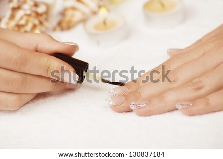 Manicure treatment -  applying cuticle oil on woman nails.