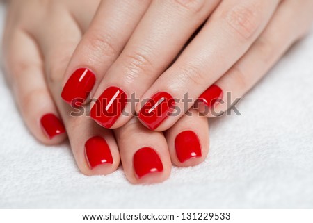 Manicure - Beautiful manicured woman\'s hands with red nail polish on soft white towel.