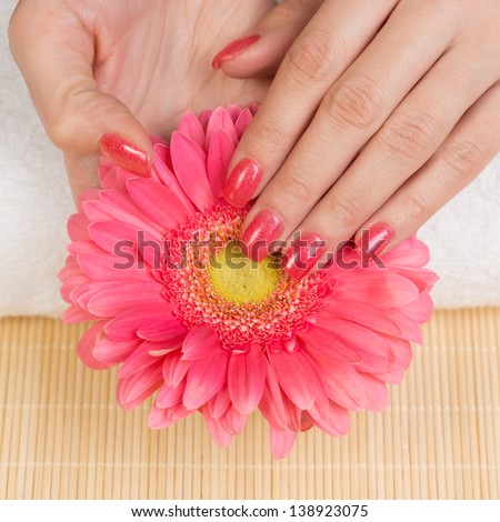 Manicure - Woman\'s hands holding flower. Studio shot. Selective focus.