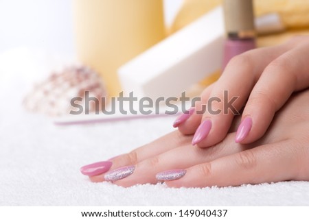 Manicure - very nice pink nail polish with glitter silver details on fingernails. Selective focus.