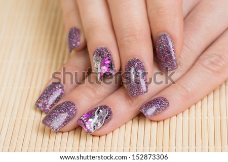Manicure - Professionally manicured woman fingernails, with interesting nail art. Studio shot. Selective focus.