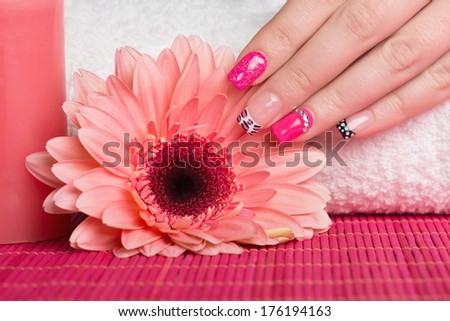 Manicure - Nice manicured woman fingernails with very interesting nail design touching flower.