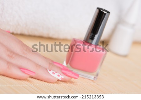 Manicure - Beauty treatment photo of nice manicured woman fingernails. Very nice feminine nail art with nice pink and white nail polish. Selective focus.