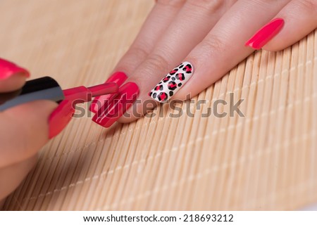 Manicure - Beauty treatment photo of nice manicured woman fingernails. Feminine nail art with interesting animal print nail art.  Selective focus.