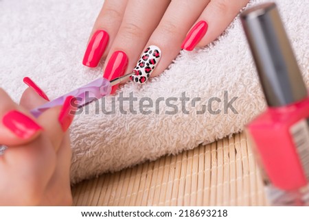 Manicure - Beauty treatment photo of nice manicured woman fingernails. Feminine nail art with interesting animal print nail art.  Selective focus.