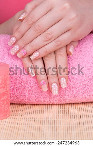 Manicure - Beauty treatment photo of nice manicured woman fingernails. Very nice feminine nail art with polka dots and bow detail.