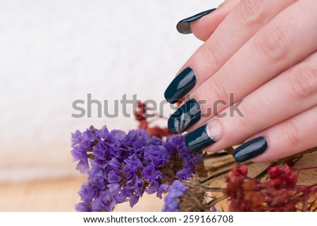 Manicure - Beauty treatment photo of nice manicured woman fingernails. Very nice nail art with petroleum blue nail polish. Selective focus.