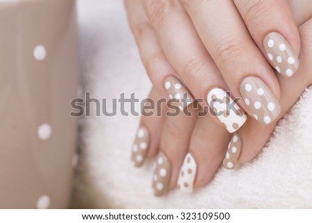 Manicure - Beauty treatment photo of nice manicured woman fingernails. Very nice feminine nail art with nice nude and white nail polish. Selective focus.