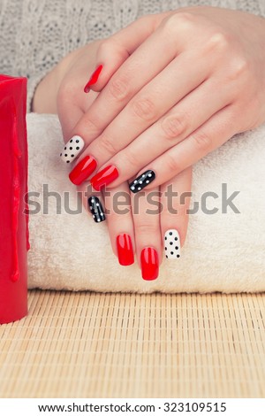 Manicure - Beauty treatment photo of nice manicured woman fingernails. Very nice feminine nail art with nice red, white and black nail polish. Processed in retro colors. Selective focus.